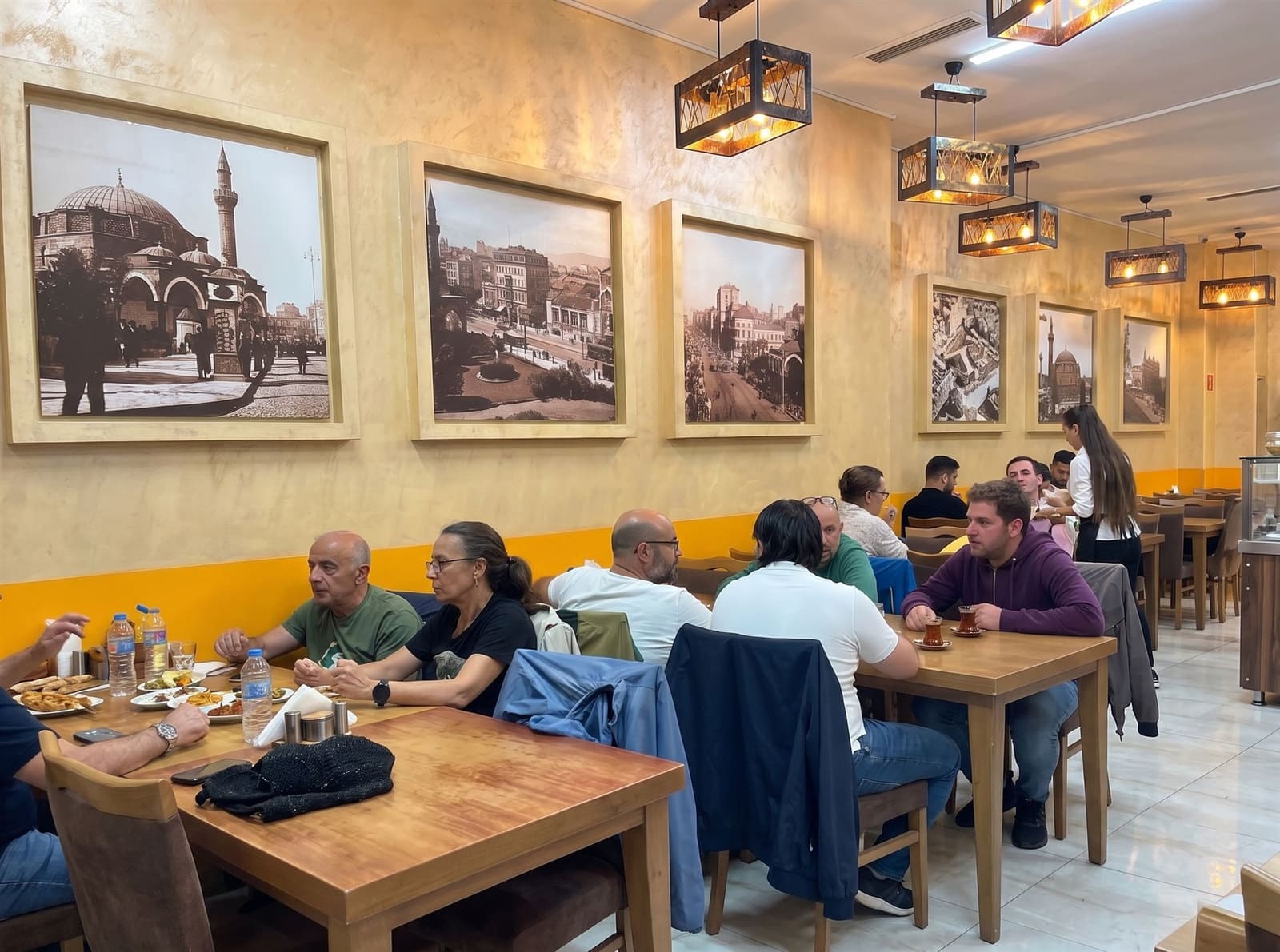 Dining room at Kadir Bey Turkish Restaurant with guests seated at wooden tables
